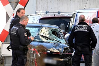 Os policiais estão ao lado de um veículo danificado no centro da cidade de Mannheim